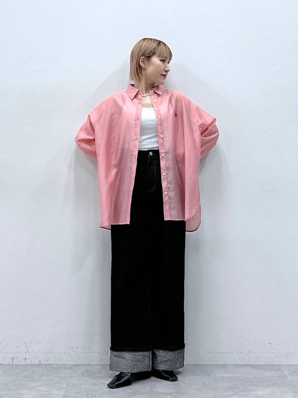 ブラック系のデニムパンツ、ピンク系のシャツ/ブラウスを着用したレディースの春コーディネートの1枚目の写真