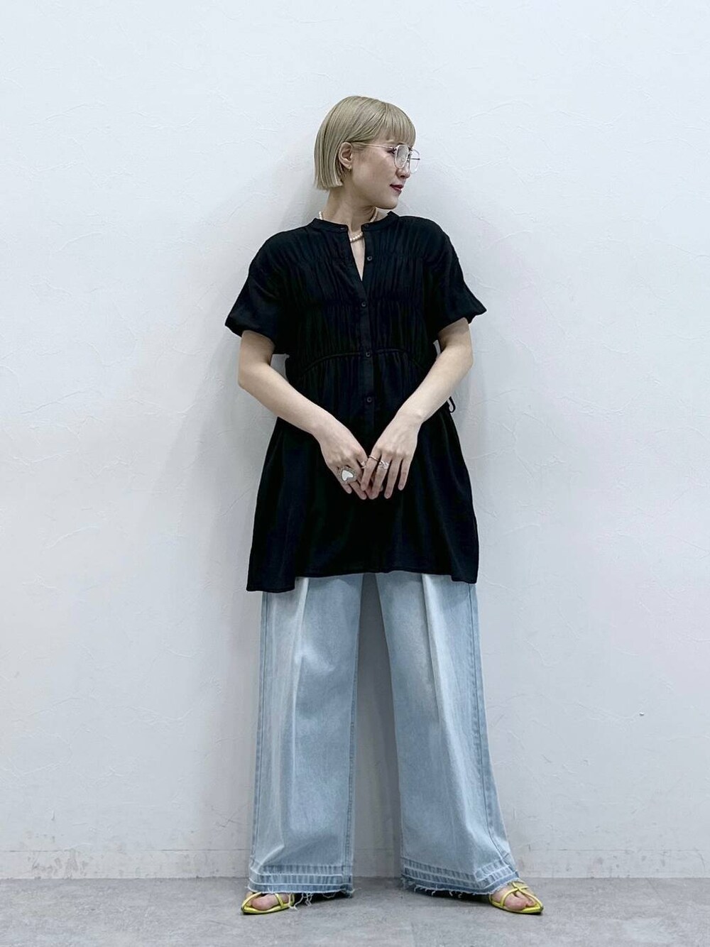 ブルー系のデニムパンツ、ブラック系のシャツ/ブラウス、ブラック系のメガネを着用したレディースの夏コーディネートの1枚目の写真