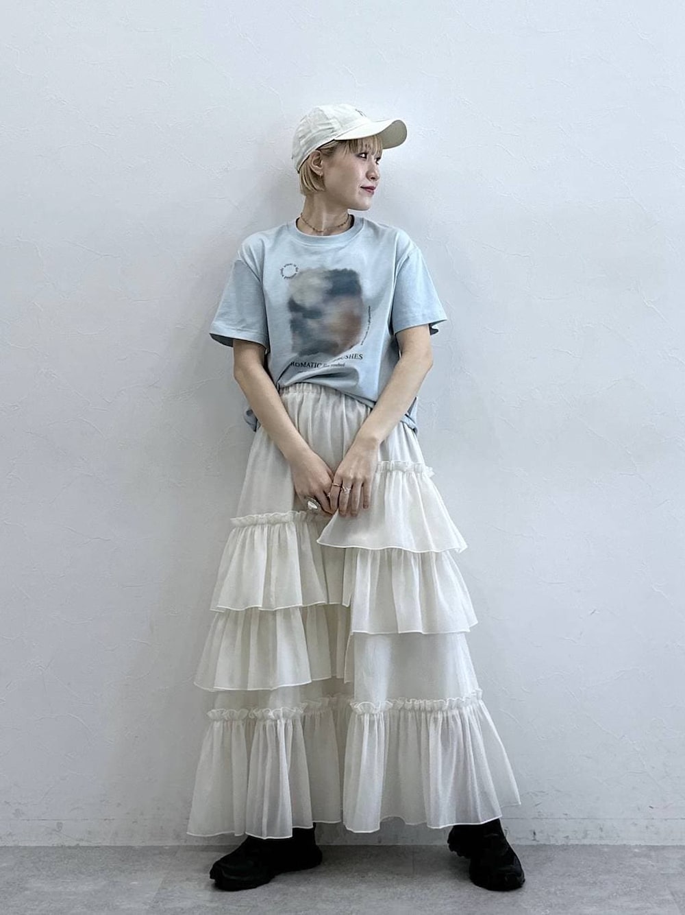 ブルー系のTシャツ/カットソー、ホワイト系のスカート、ホワイト系のキャップを着用したレディースの春コーディネートの1枚目の写真
