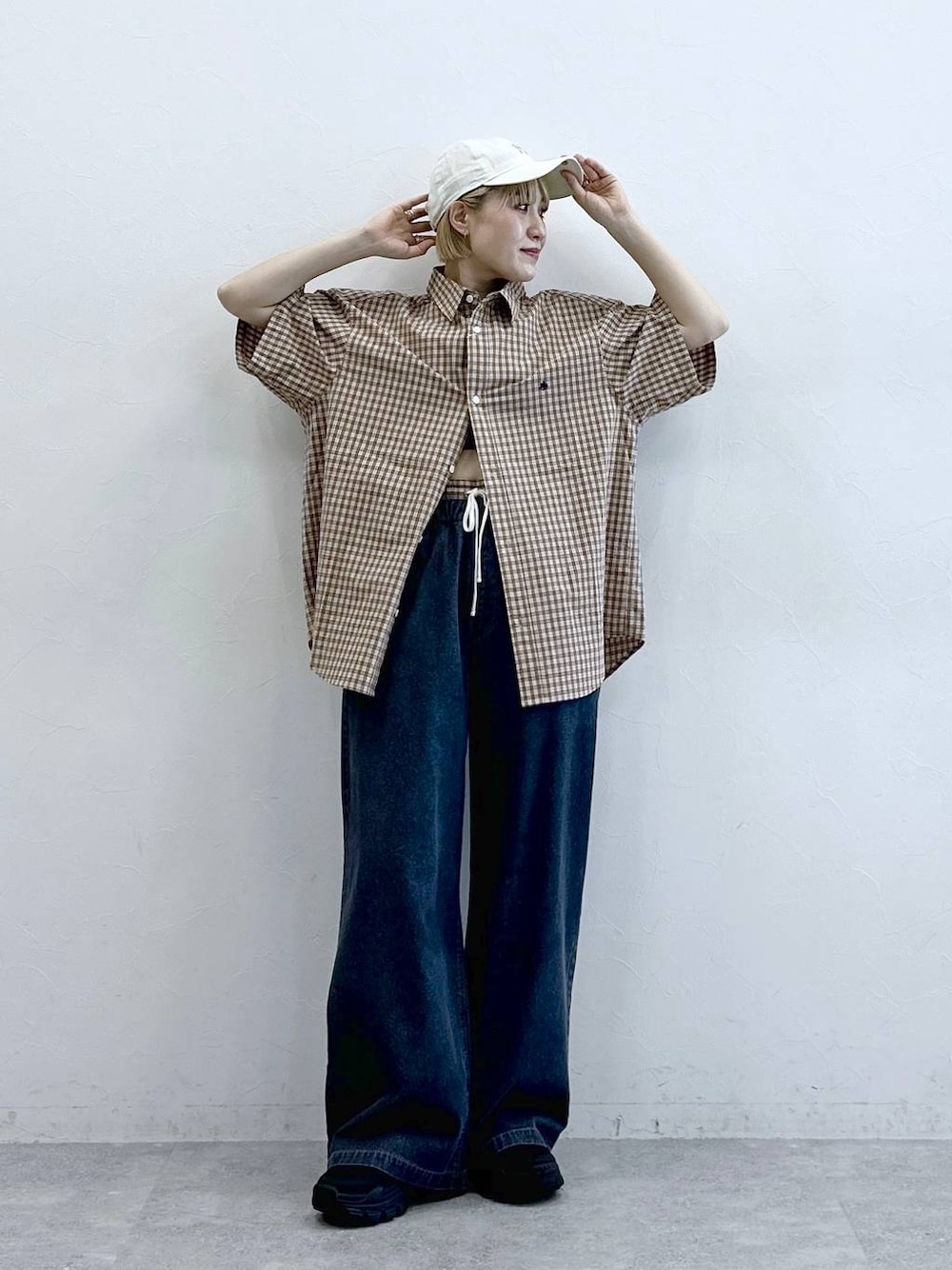 ベージュ系のその他パンツ、ベージュ系のシャツ/ブラウス、ホワイト系のキャップを着用したレディースの春コーディネートの1枚目の写真