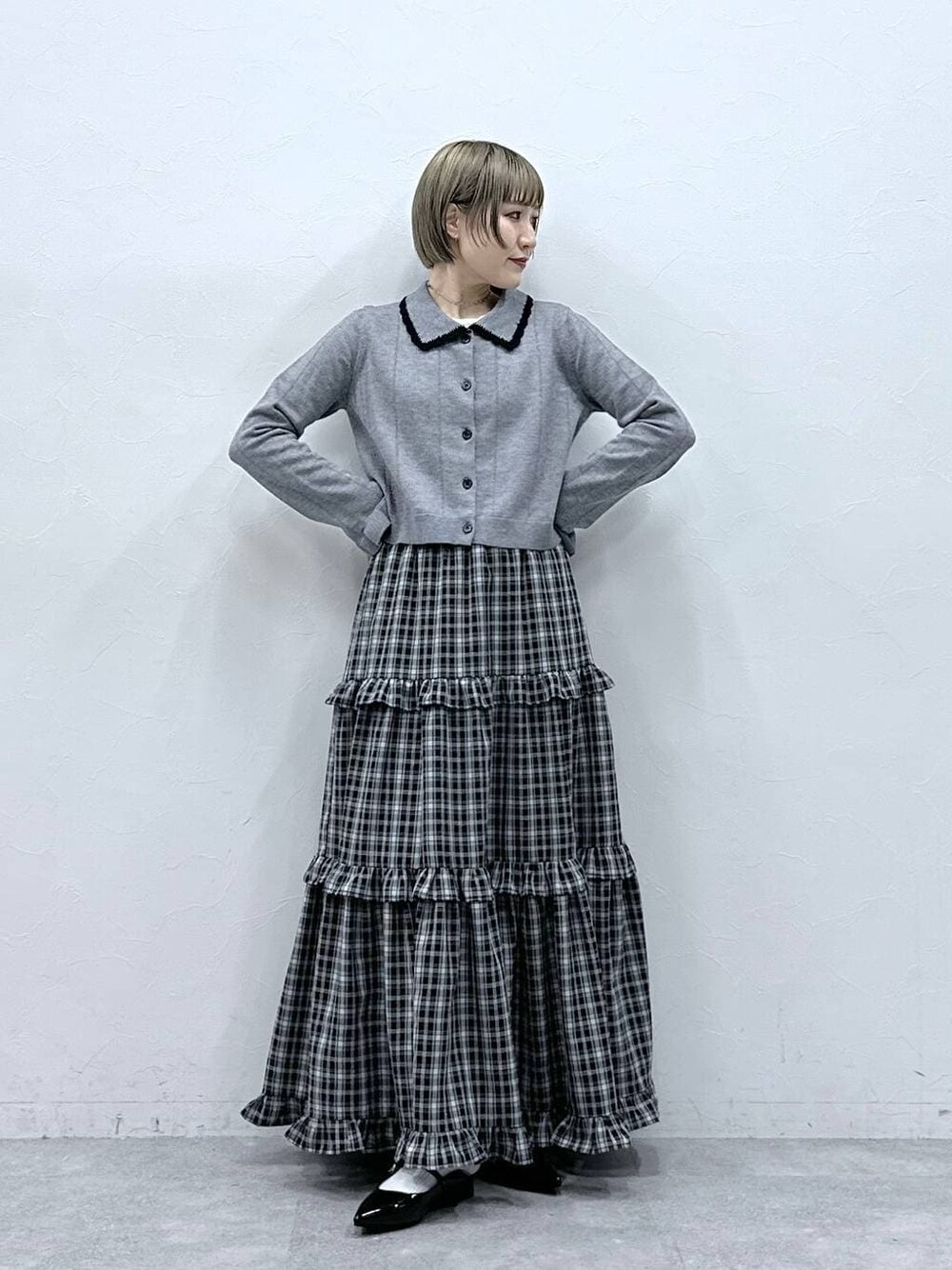 ホワイト系のTシャツ/カットソー、ブラック系のパンプス、グレー系のカーディガン/ボレロを着用したレディースの冬コーディネートの1枚目の写真