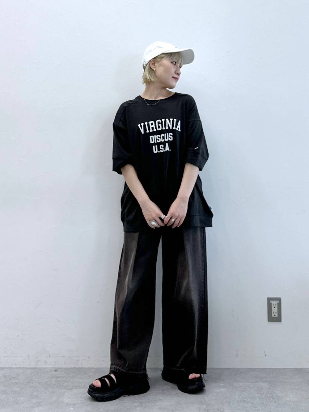 ブルー系のデニムパンツ、ブラック系のサンダル、ホワイト系のTシャツ/カットソーを着用したレディースの夏コーディネートの1枚目の写真