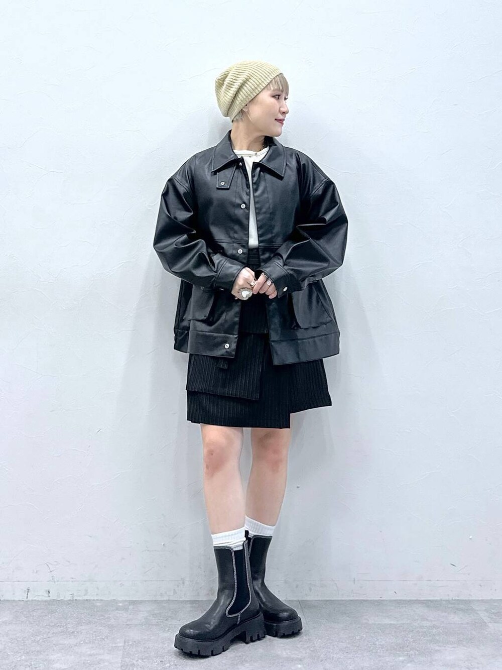 ブラック系のブーツ、ホワイト系のTシャツ/カットソー、ブラック系のスカートを着用したレディースの秋コーディネートの1枚目の写真