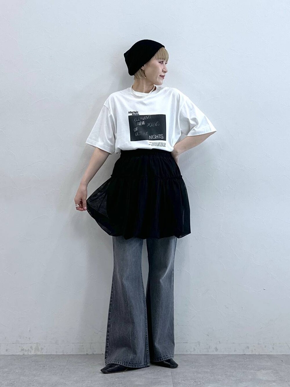 グレー系のデニムパンツ、ブラック系のスカート、ブラック系のニットキャップ/ビーニーを着用したレディースの夏コーディネートの1枚目の写真