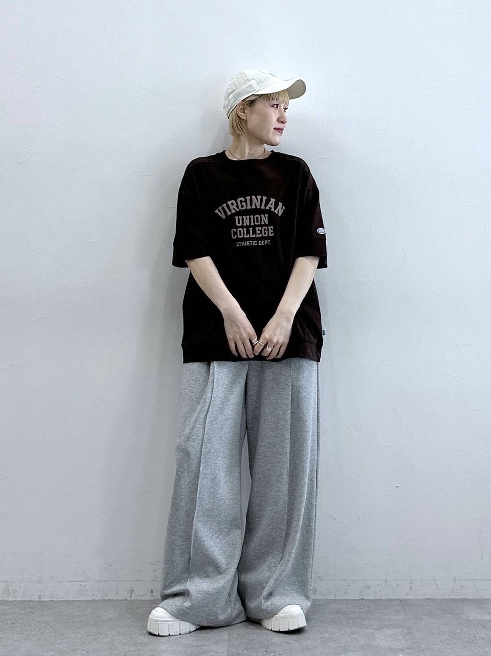 ブラウン系のTシャツ/カットソー、グレー系のスウェットパンツ、ホワイト系のキャップを着用したレディースの春コーディネートの1枚目の写真