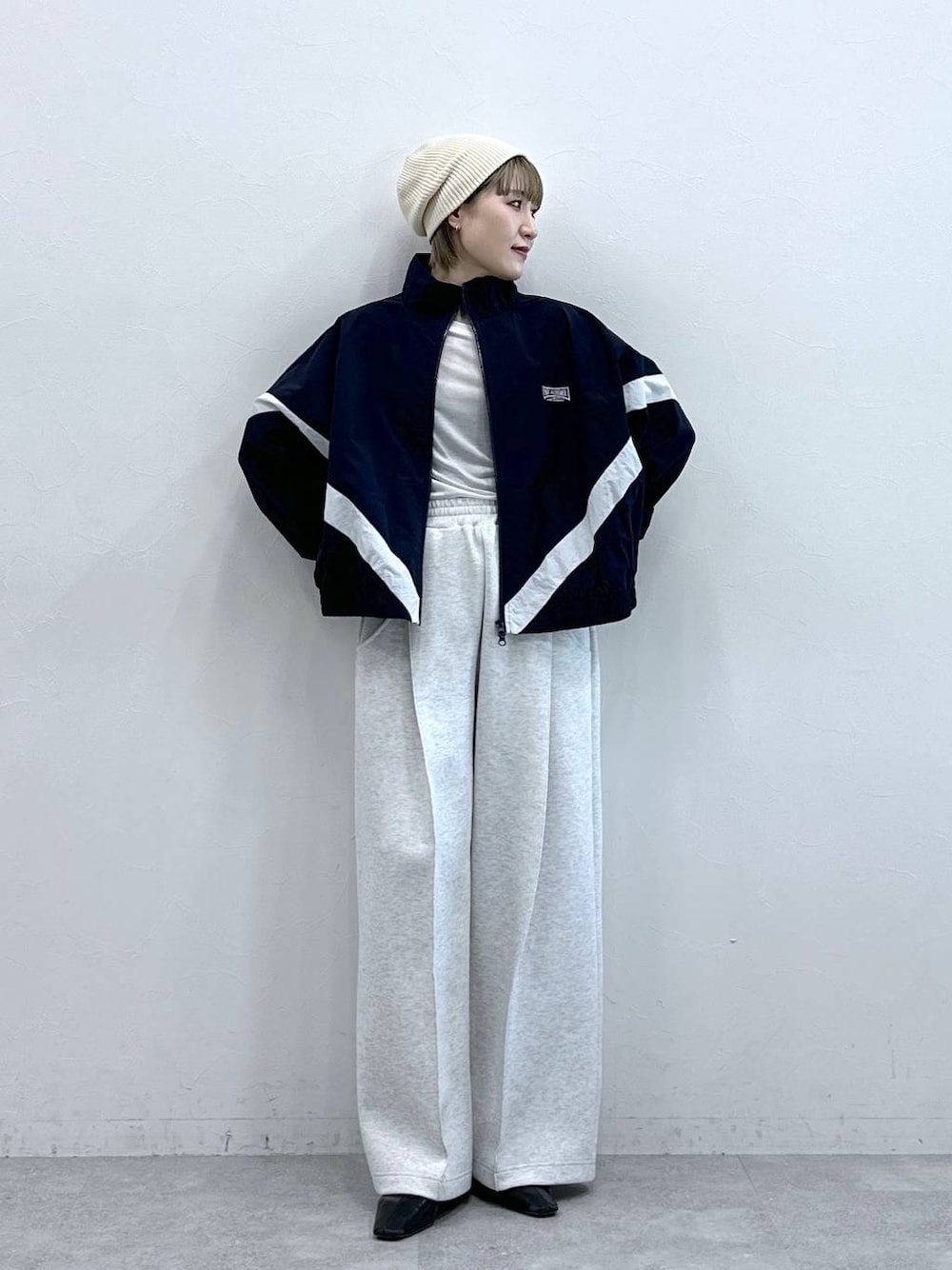 ホワイト系のスウェットパンツ、ブルー系のブルゾン、ホワイト系のTシャツ/カットソーを着用したレディースの冬コーディネートの1枚目の写真