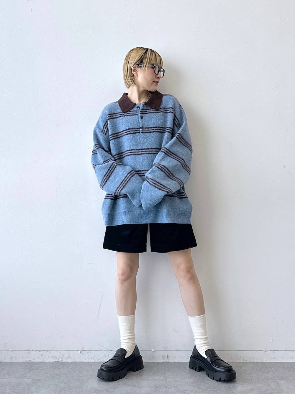 ブラック系のローファー、ブラック系のその他パンツ、ブルー系のポロシャツを着用したレディースの秋コーディネートの1枚目の写真