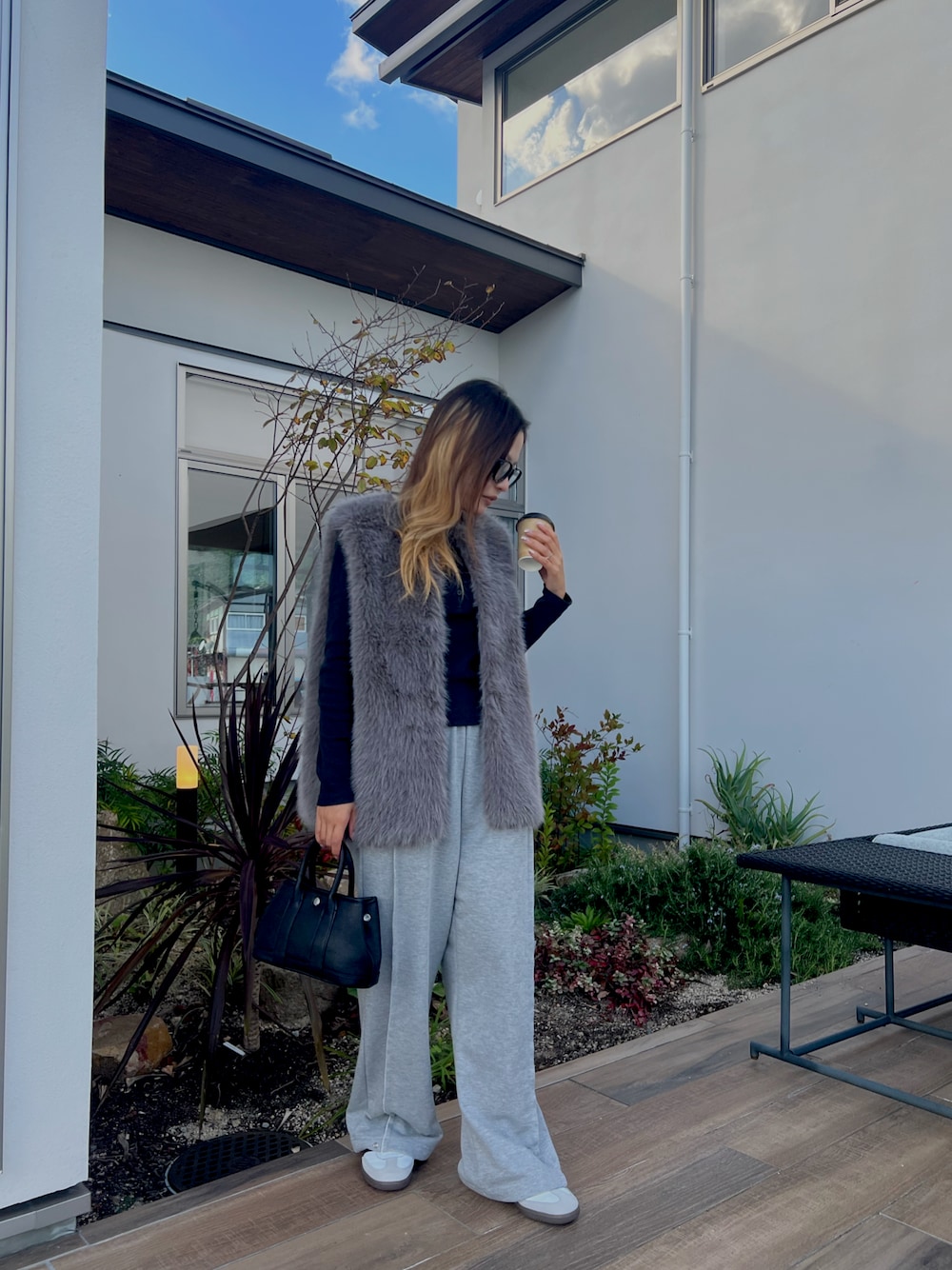 ブラック系のニット/セーター、グレー系のその他アウター、グレー系のスウェットパンツを着用したレディースの秋コーディネートの1枚目の写真