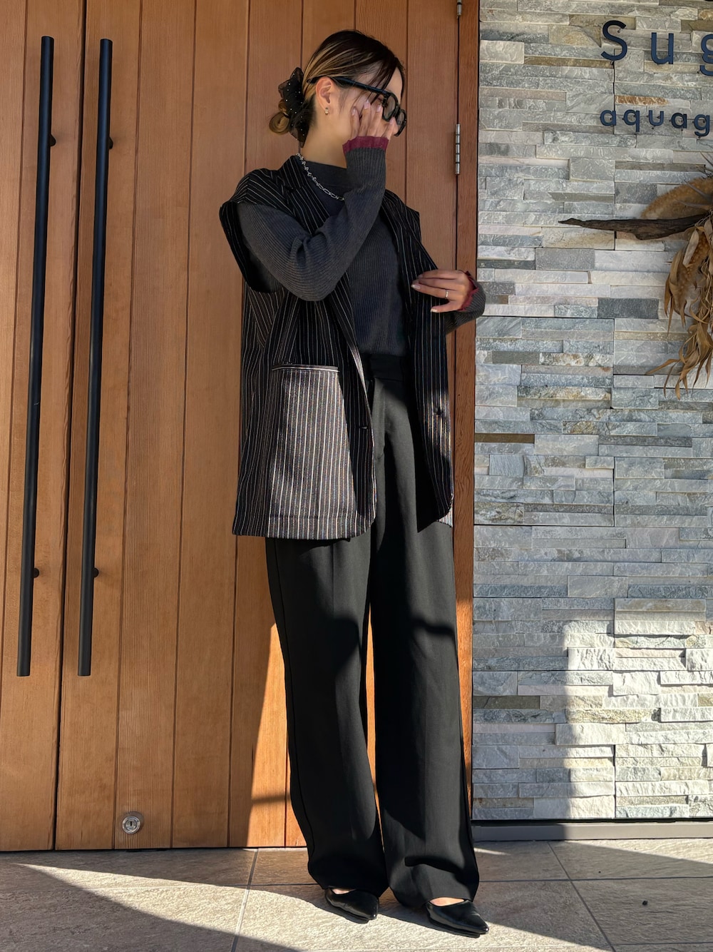 グレー系のニット/セーター、ブラック系のその他アウター、ブラック系のパンツを着用したレディースの秋コーディネートの1枚目の写真