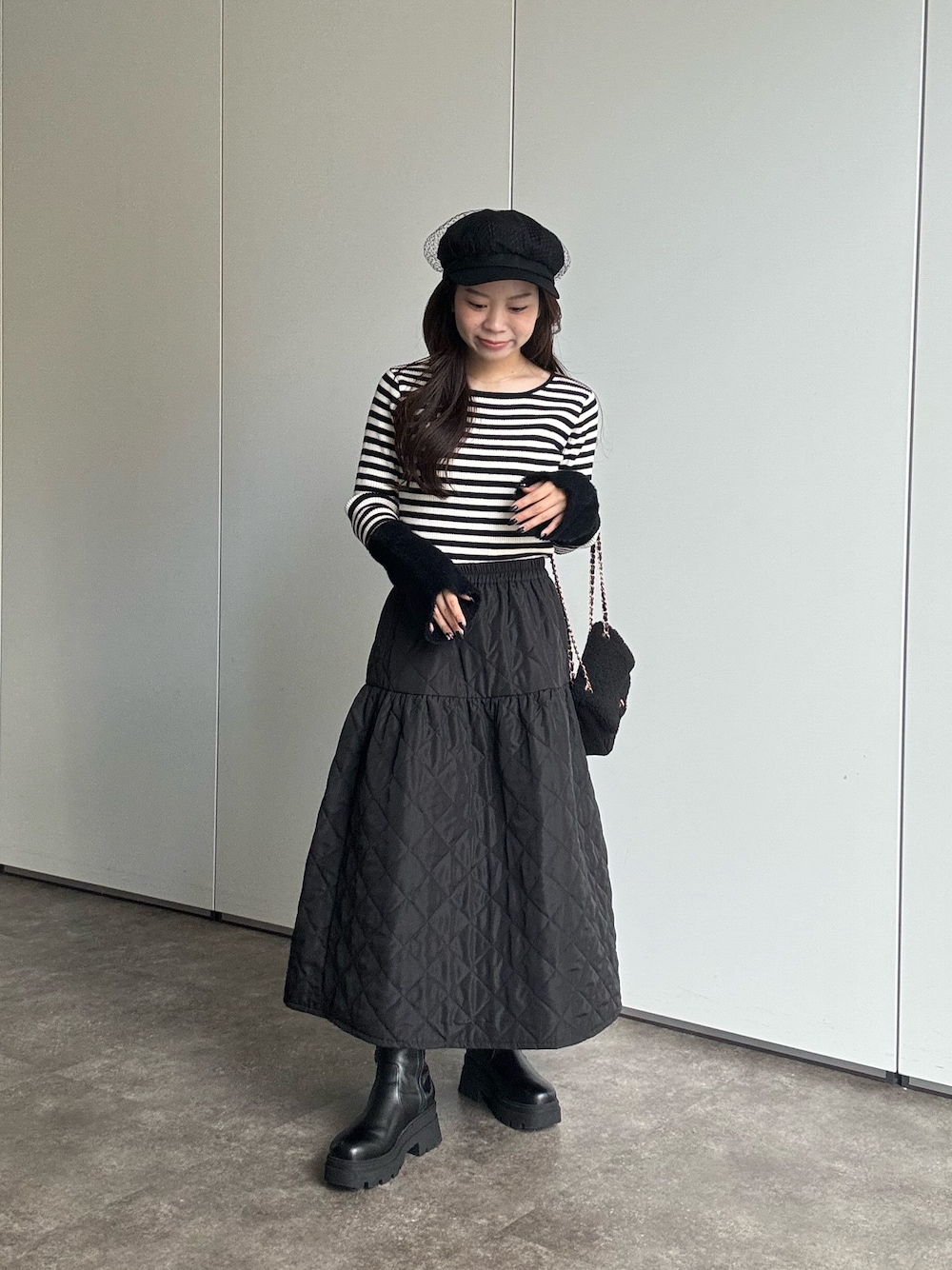 ブラック系のニット/セーター、ブラック系のショルダーバッグ、ブラック系のブーツを着用したレディースの秋コーディネートの1枚目の写真