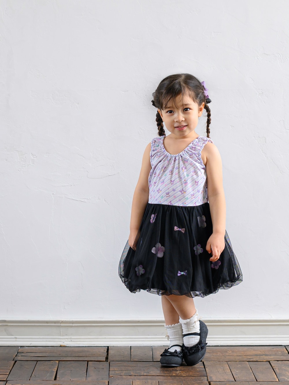 ブラック系のワンピース、ブラック系のバレエシューズ、ホワイト系のソックス/靴下を着用したキッズの春コーディネートの1枚目の写真