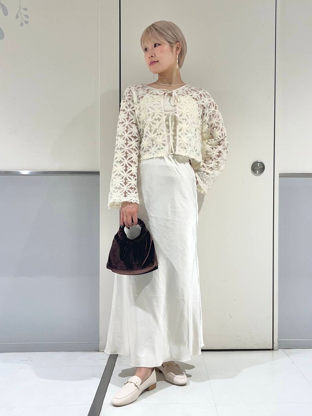 ホワイト系のローファー、ホワイト系のキャミソール、ブラウン系のハンドバッグを着用したレディースの秋コーディネートの1枚目の写真