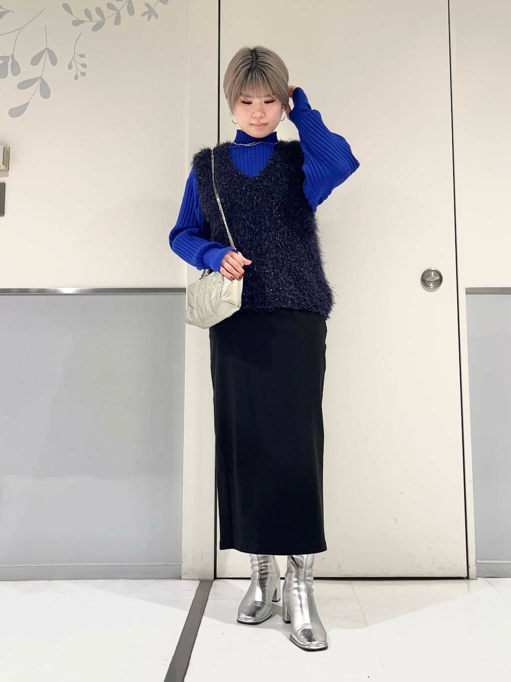 シルバー系のブーツ、ブルー系のベスト、ブルー系のニット/セーターを着用したレディースの冬コーディネートの1枚目の写真