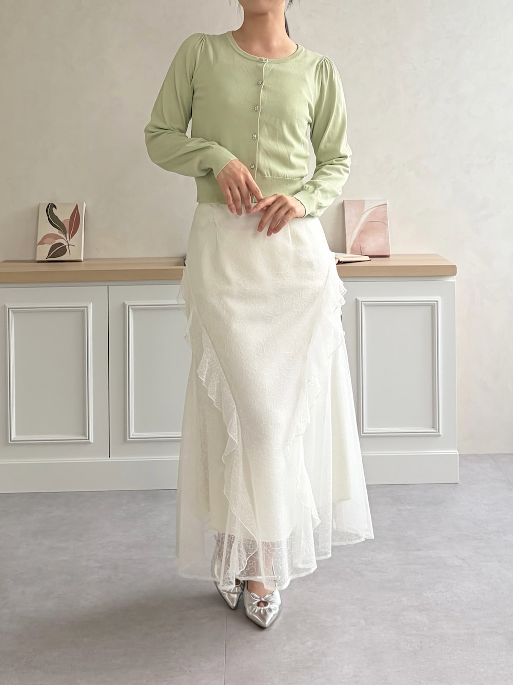 グリーン系のカーディガン/ボレロ、ホワイト系のスカートを着用したレディースの夏コーディネートの1枚目の写真