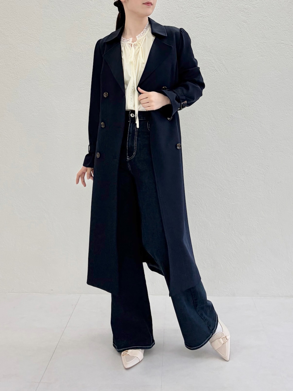 ブルー系のデニムパンツ、ブルー系のトレンチコート、イエロー系のシャツ/ブラウスを着用したレディースの春コーディネートの1枚目の写真