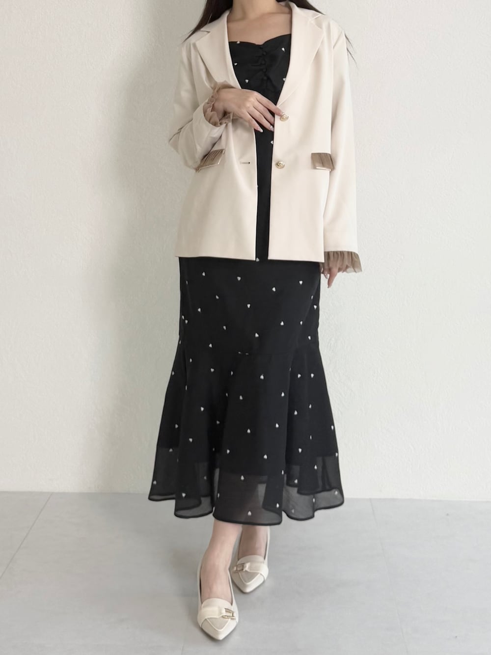 ホワイト系のテーラードジャケット、ブラック系のワンピース、ベージュ系のシューズを着用したレディースの春コーディネートの1枚目の写真