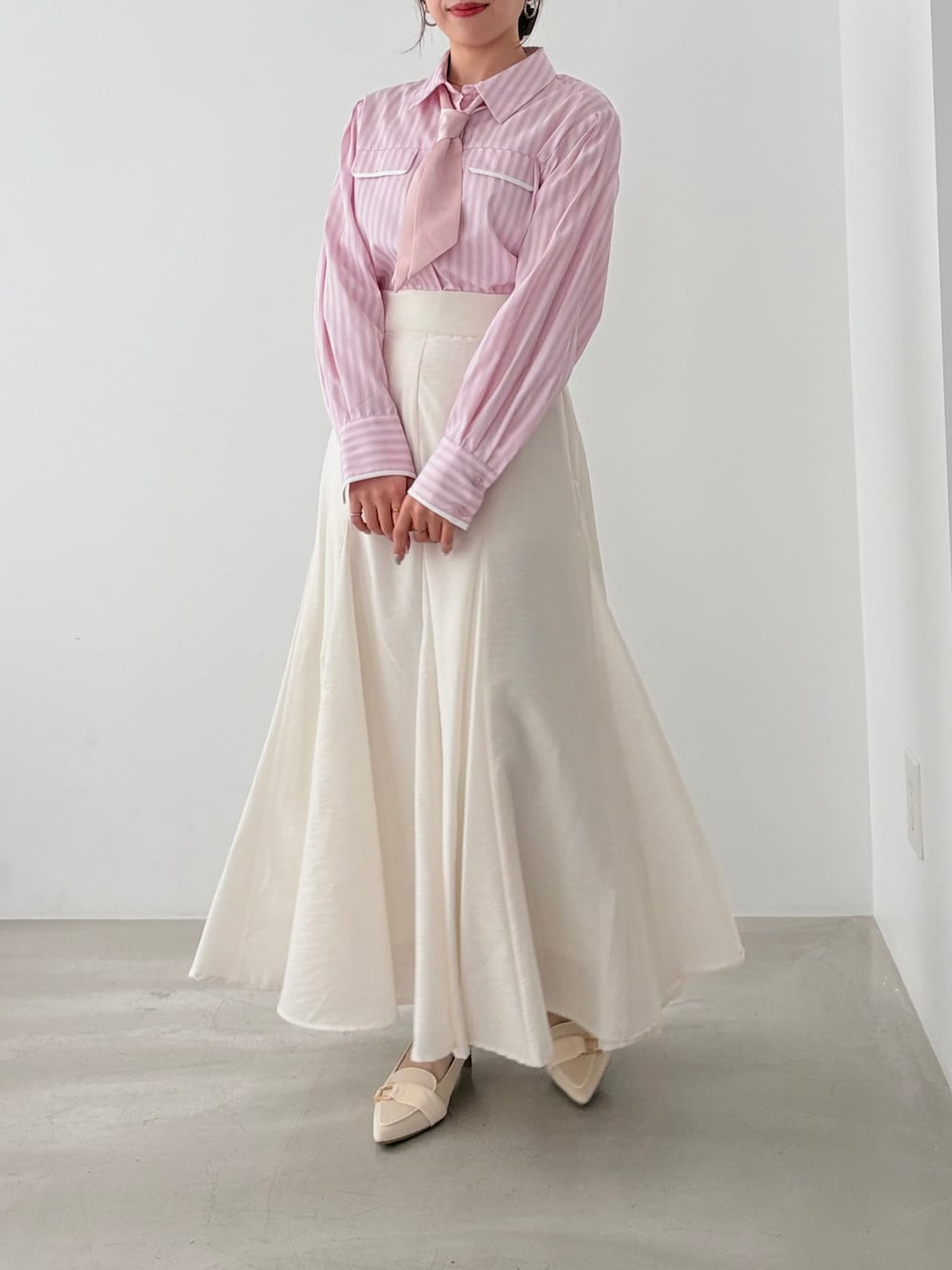 ピンク系のシャツ/ブラウス、ホワイト系のスカートを着用したレディースの春コーディネートの1枚目の写真