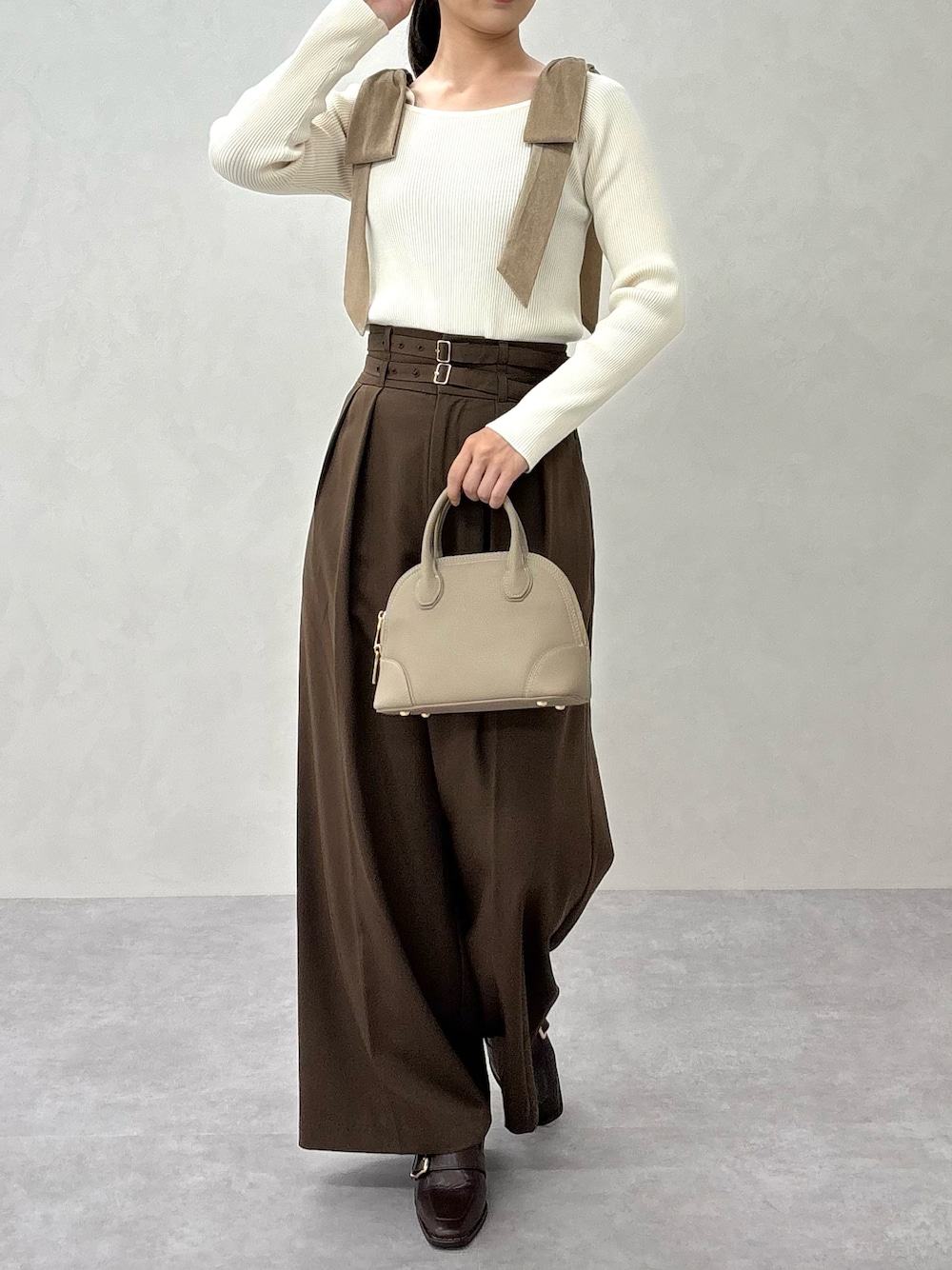 ベージュ系のニット/セーター、ブラウン系のスラックス、ブラウン系のパンプスを着用したレディースの秋コーディネートの1枚目の写真