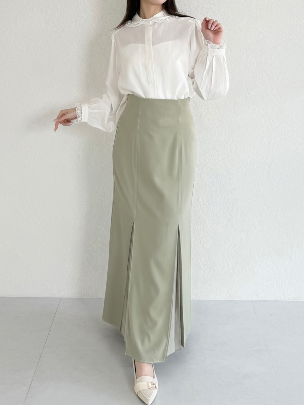 グリーン系のスカート、ベージュ系のシューズ、ホワイト系のシャツ/ブラウスを着用したレディースの春コーディネートの1枚目の写真