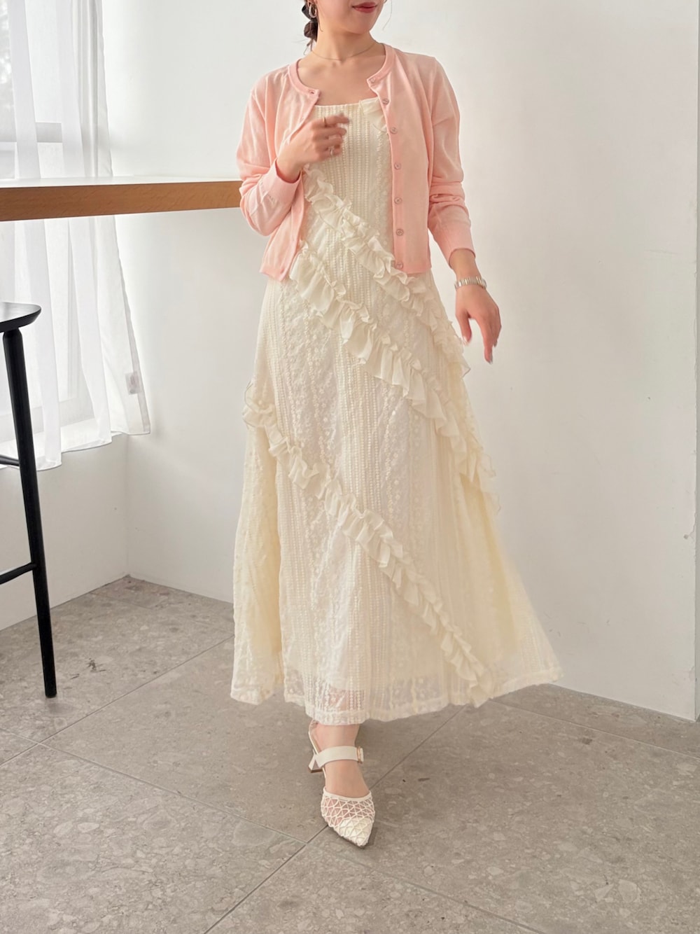 ホワイト系のワンピース、ピンク系のカーディガン/ボレロを着用したレディースの春コーディネートの1枚目の写真