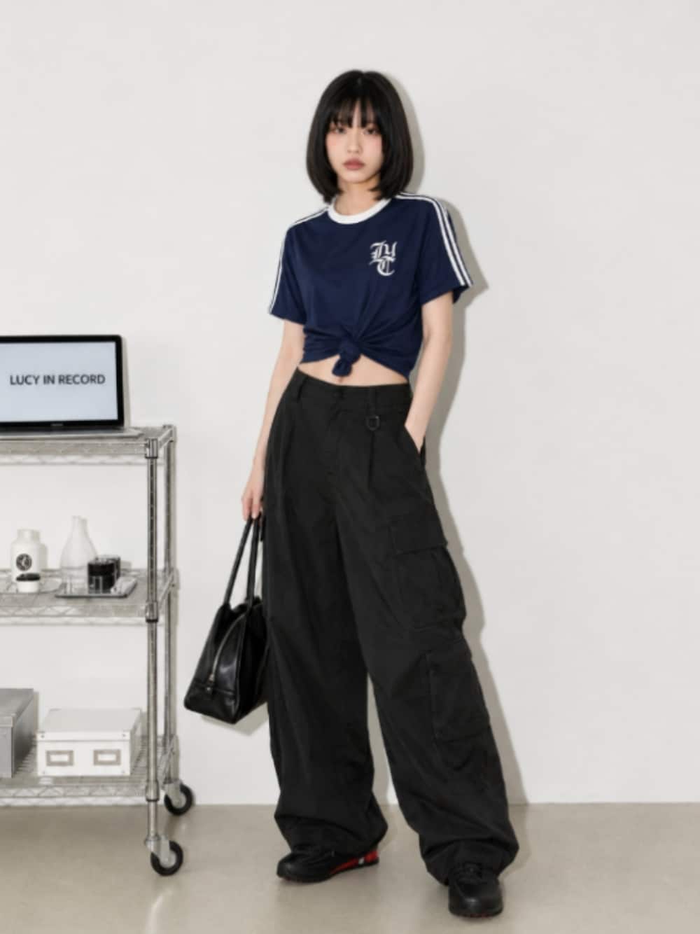 ブラック系のスニーカー、ブラック系のカーゴパンツ、ブルー系のその他トップスを着用したレディースの秋コーディネートの1枚目の写真