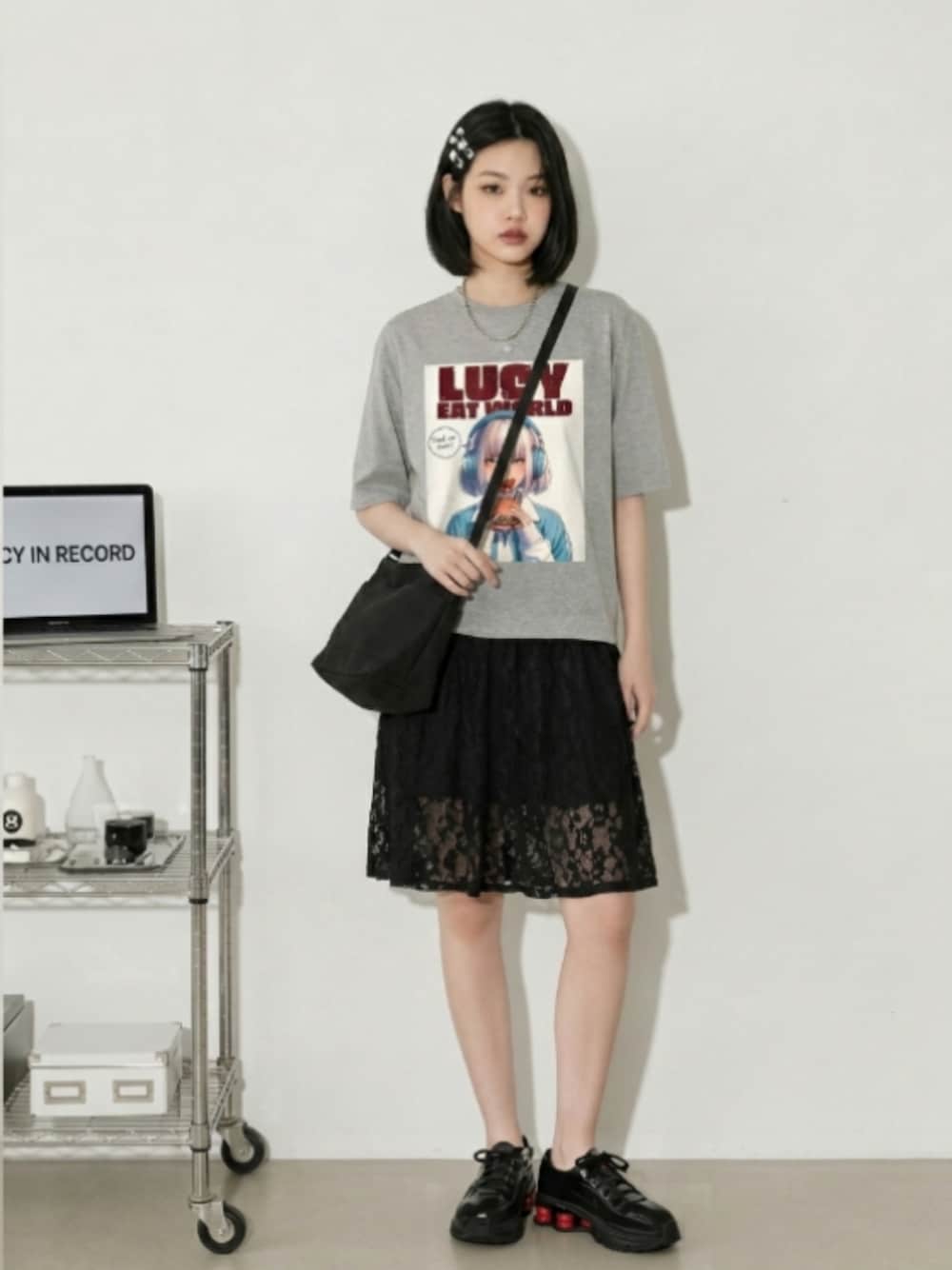ブラック系のスニーカー、ブラック系のスカート、ホワイト系のTシャツ/カットソーを着用したレディースの夏コーディネートの1枚目の写真