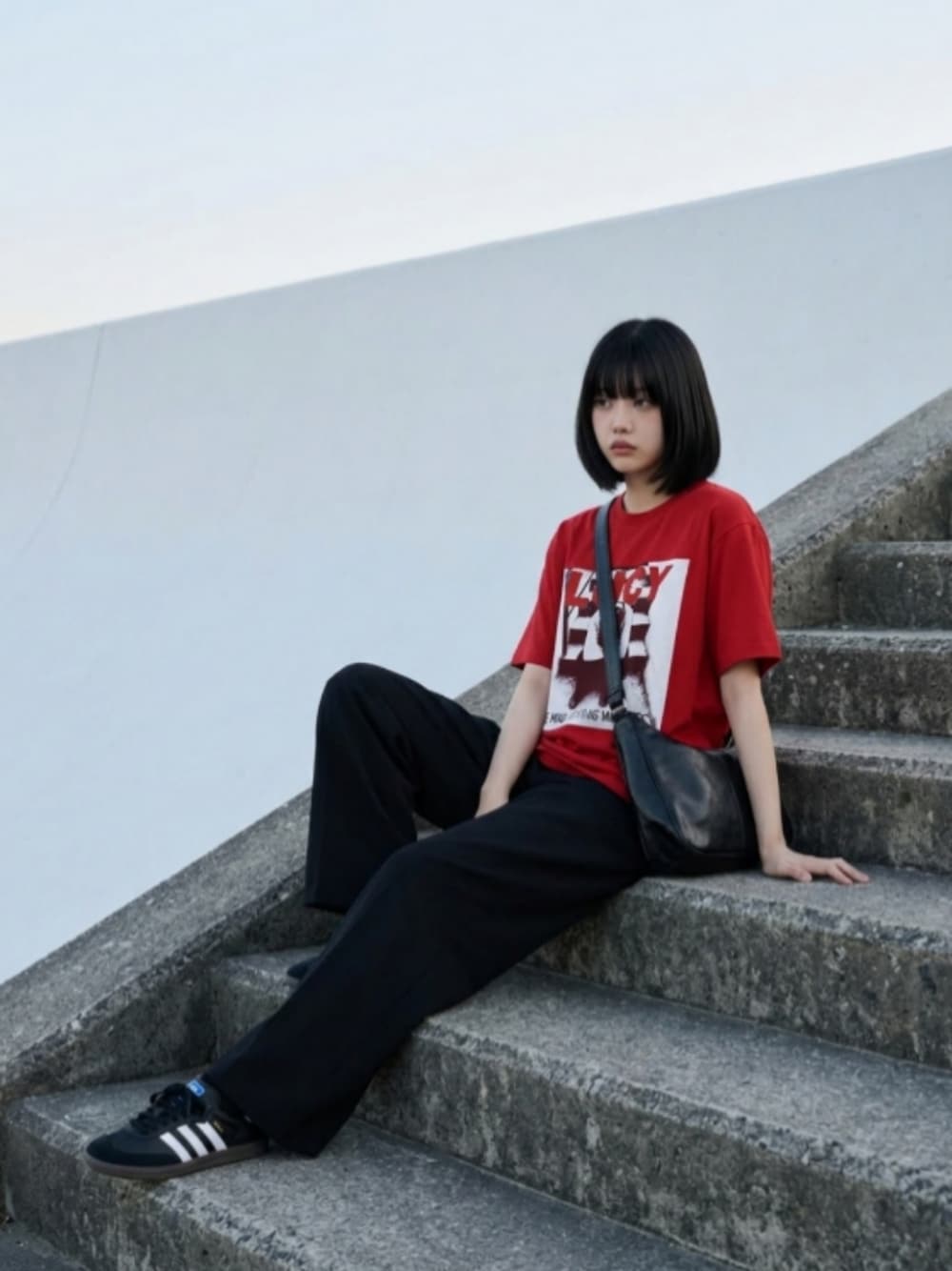 ブラック系のスニーカー、ブラック系のスラックス、ホワイト系のTシャツ/カットソーを着用したレディースの夏コーディネートの1枚目の写真