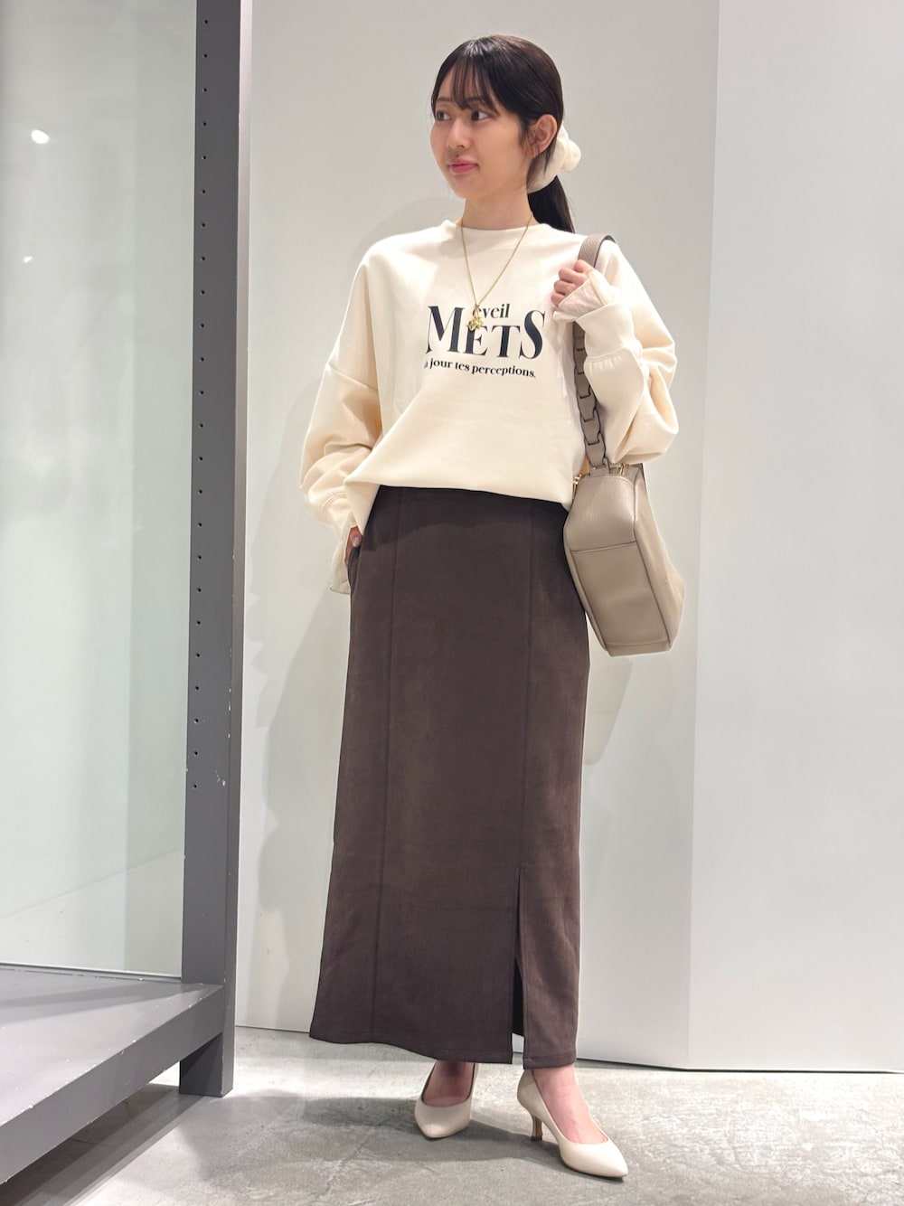 ホワイト系のスウェット、ホワイト系のTシャツ/カットソー、ブラウン系のスカートを着用したレディースの秋コーディネートの1枚目の写真