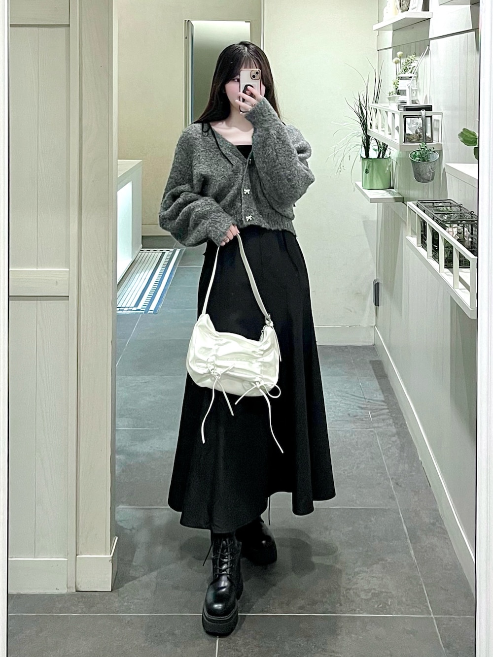 ブラック系のワンピース、グレー系のカーディガン/ボレロ、ホワイト系のショルダーバッグを着用したレディースの秋コーディネートの1枚目の写真