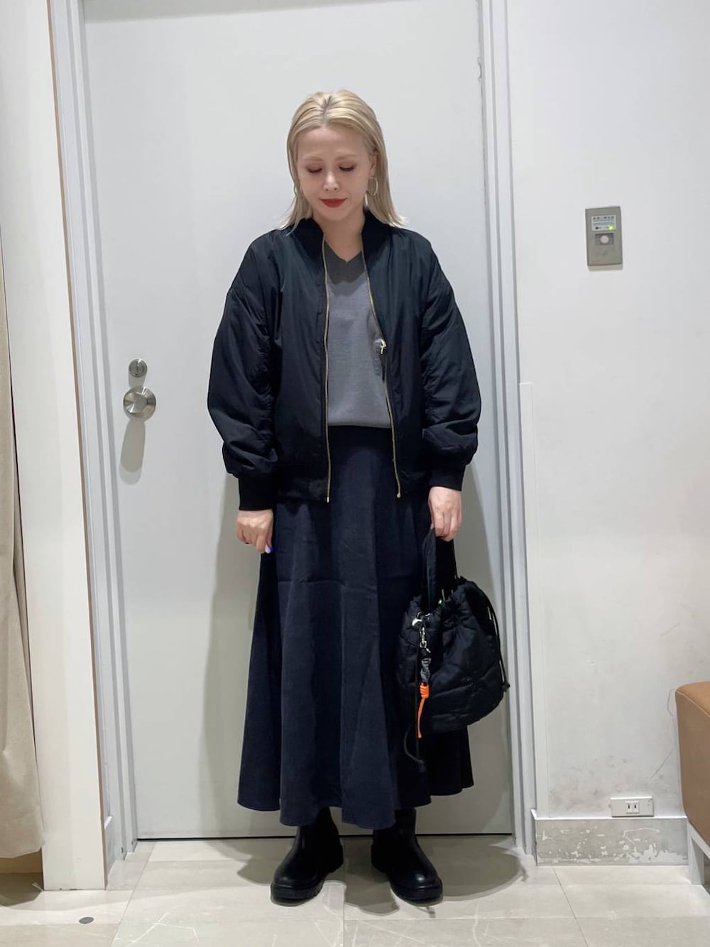 ベージュ系のブルゾン、グレー系のスウェット、グレー系のスカートを着用したレディースの秋コーディネートの1枚目の写真