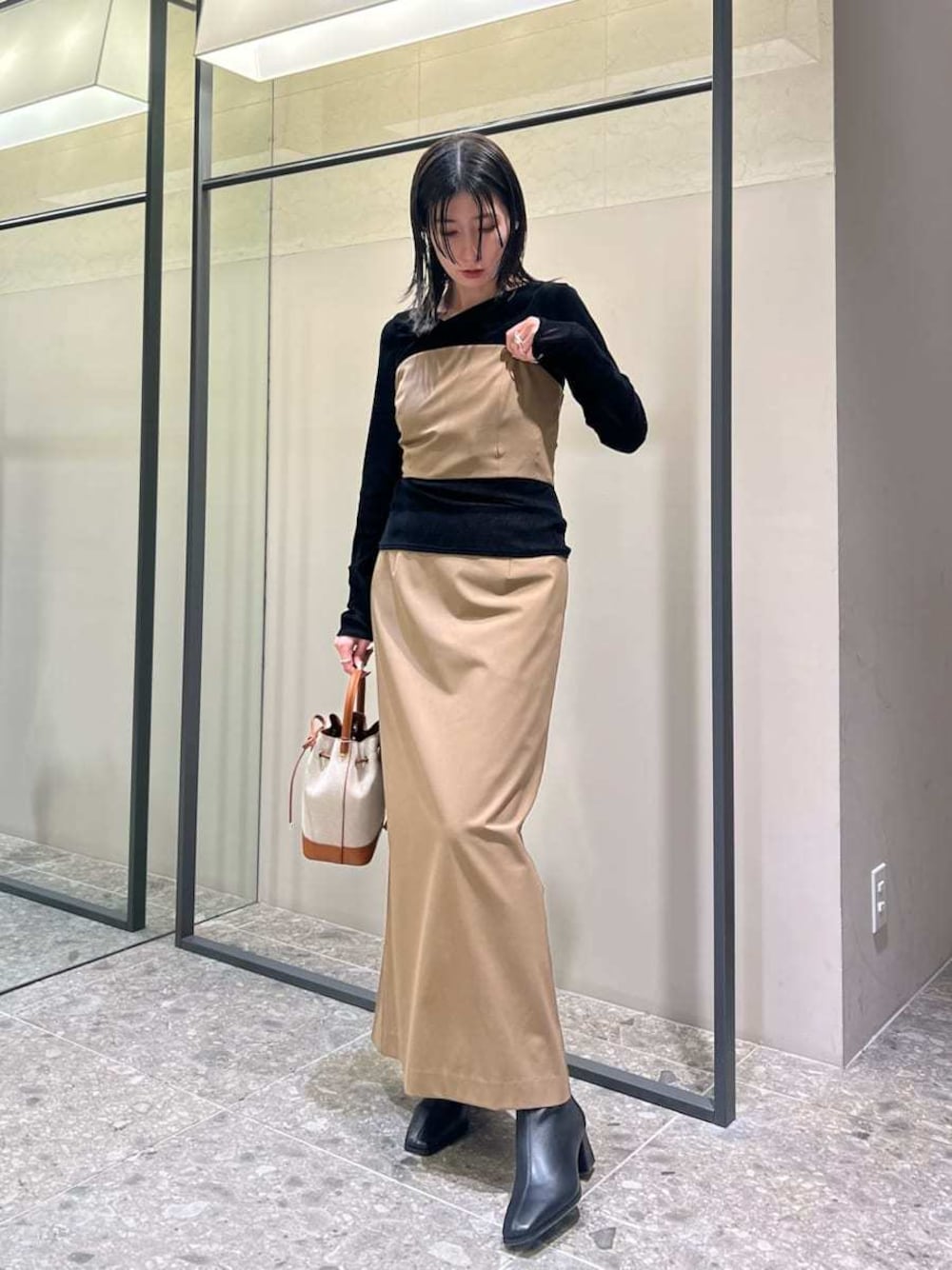 イエロー系のワンピース、ブラック系のTシャツ/カットソー、イエロー系のショルダーバッグを着用したレディースの秋コーディネートの1枚目の写真