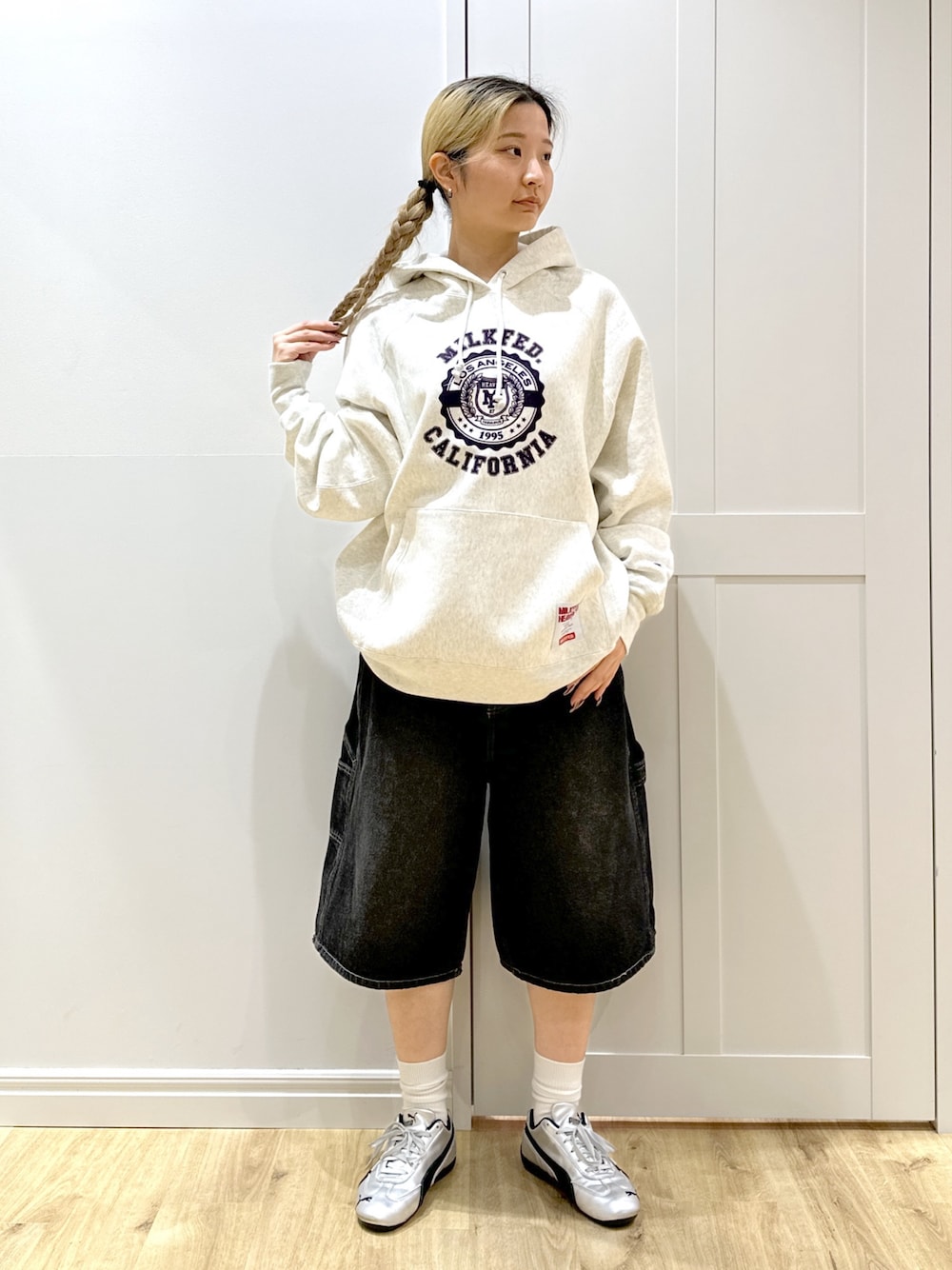 ベージュ系のパーカー、ブラック系のデニムパンツ、ブラック系のバックパック/リュックを着用したレディースの秋コーディネートの1枚目の写真