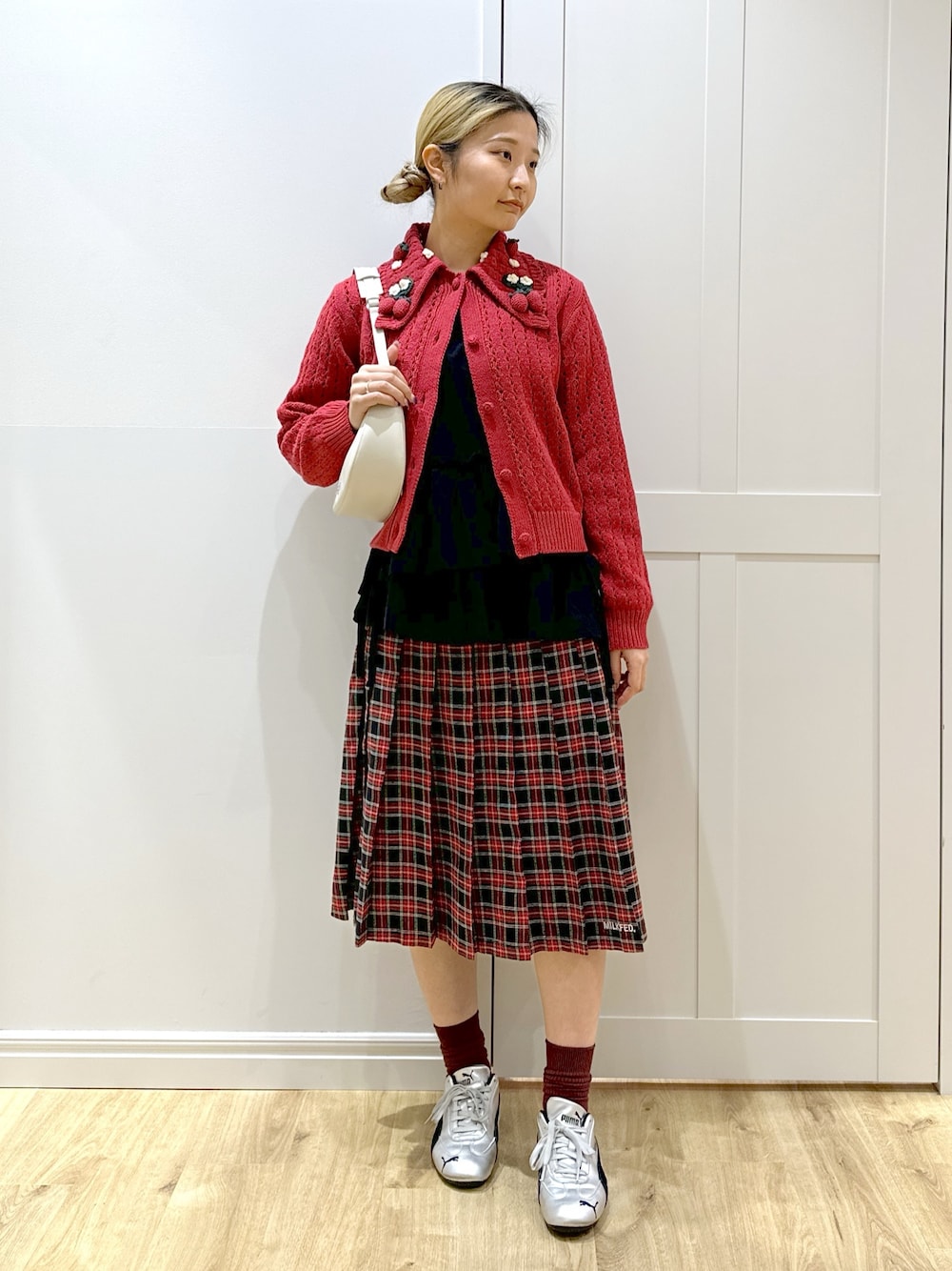 レッド系のカーディガン/ボレロ、ホワイト系のTシャツ/カットソー、ブラック系のスカートを着用したレディースの秋コーディネートの1枚目の写真