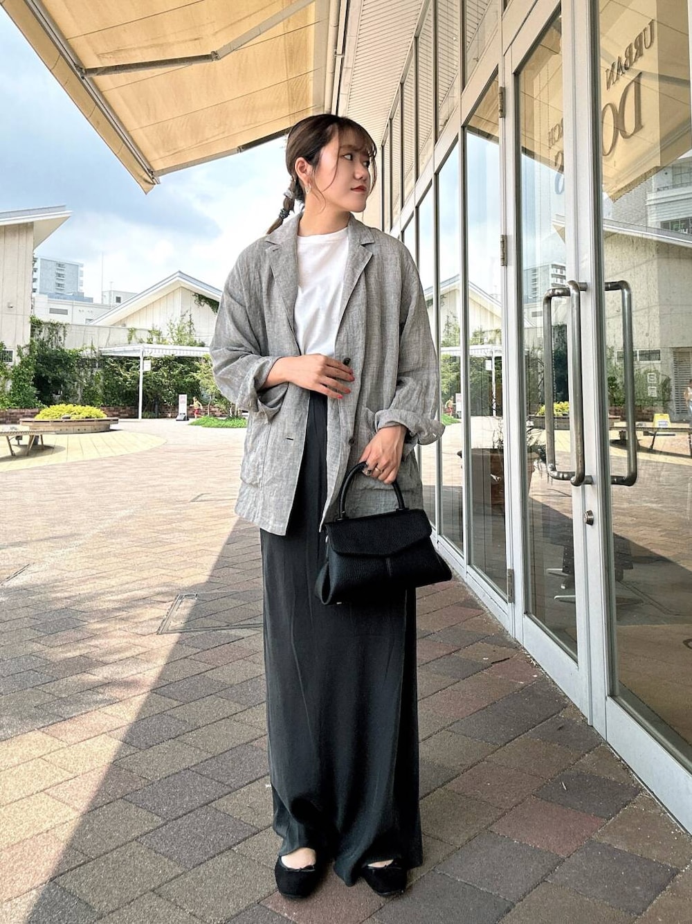 ホワイト系のTシャツ/カットソー、ブラック系のバレエシューズ、ブラック系のショルダーバッグを着用したレディースの夏コーディネートの1枚目の写真