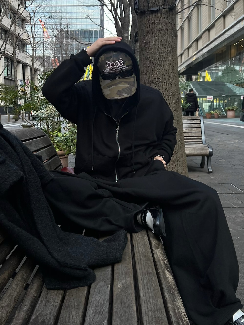 ブラック系のパーカー、ブラック系のローファー、その他のキャップを着用したメンズの秋コーディネートの1枚目の写真