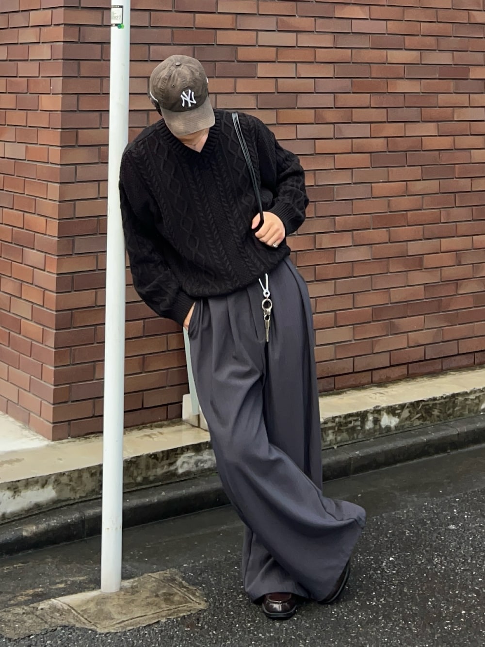 ブラック系のニット/セーター、ブラック系のショルダーバッグ、グレー系のその他パンツを着用したメンズの秋コーディネートの1枚目の写真