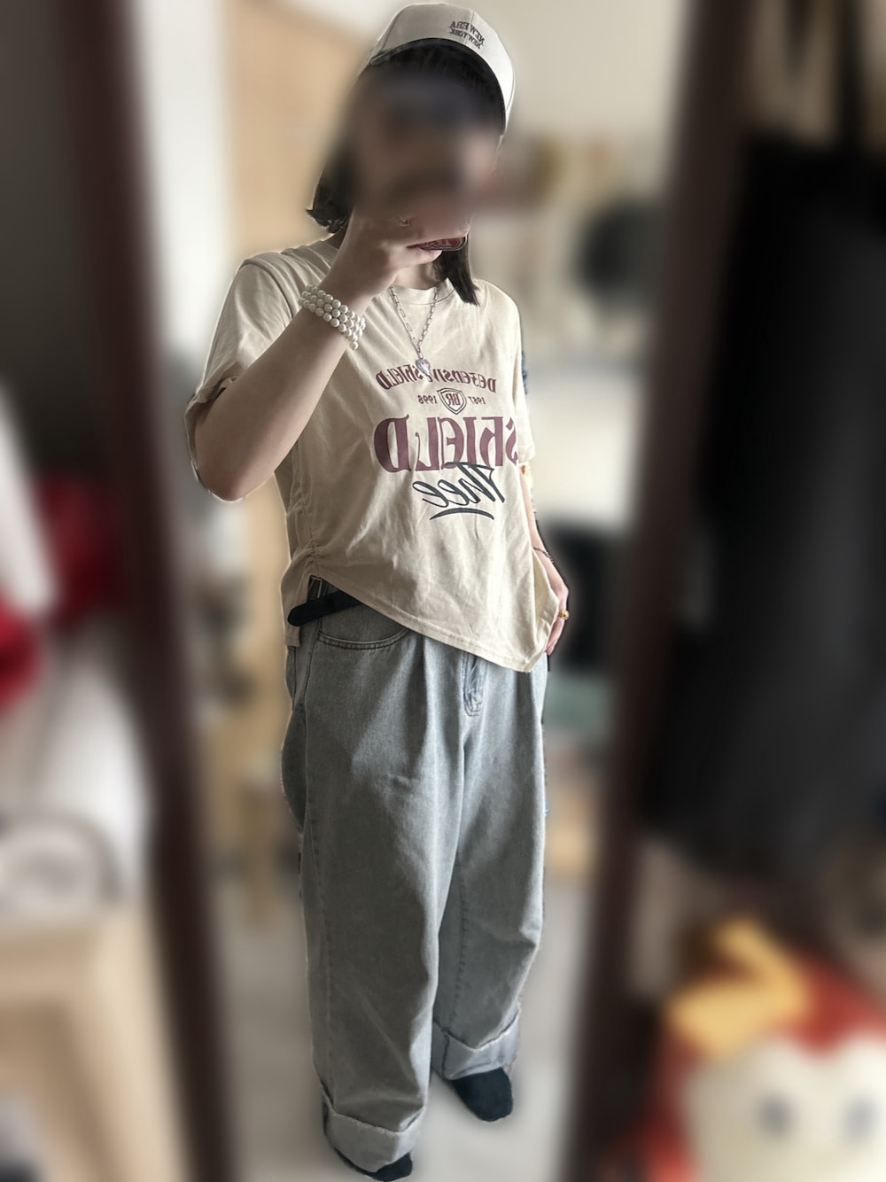 ブルー系のデニムパンツ、ゴールド系のブレスレット、ベージュ系のキャップを着用したレディースの夏コーディネートの1枚目の写真