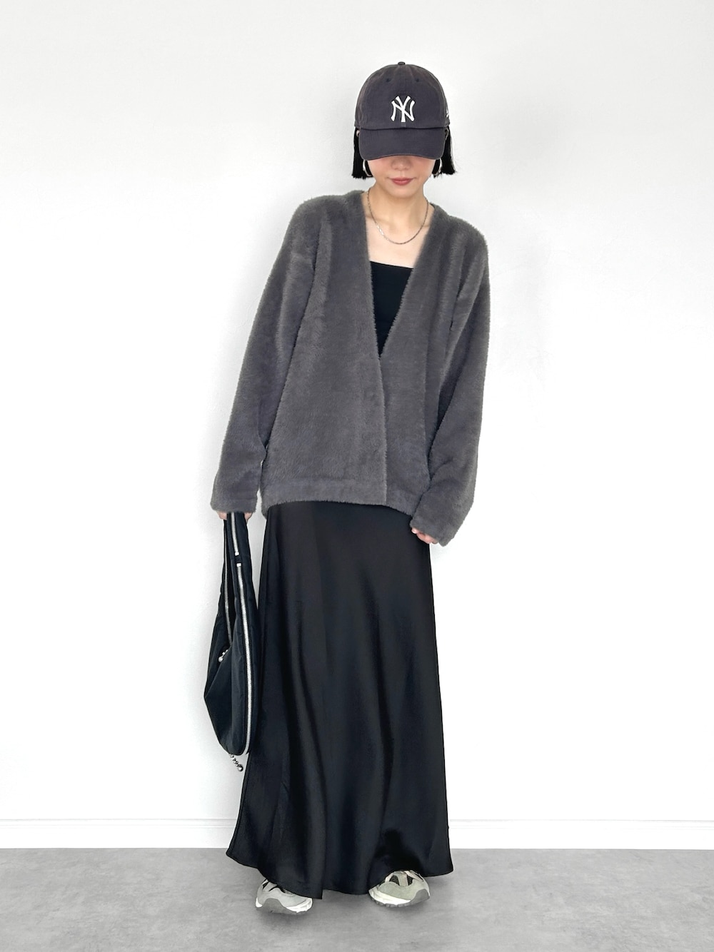 グレー系のカーディガン/ボレロ、ブラック系のショルダーバッグ、ブラック系のスカートを着用したレディースの秋コーディネートの1枚目の写真