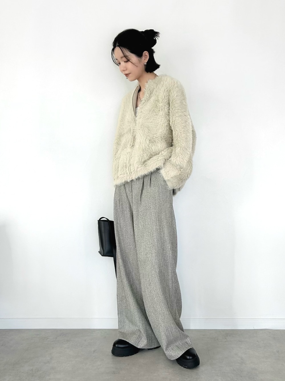 ホワイト系のカーディガン/ボレロ、ベージュ系のパンツ、ブラック系のトートバッグを着用したレディースの秋コーディネートの1枚目の写真