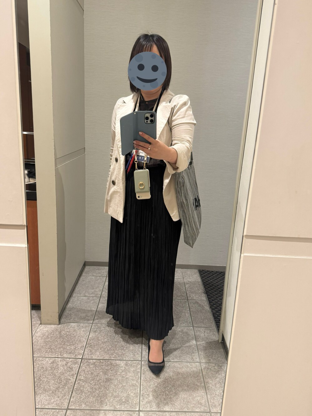 ブラック系のスカート、ブラウン系のトップス、ベージュ系のテーラードジャケットを着用したレディースの夏コーディネートの1枚目の写真