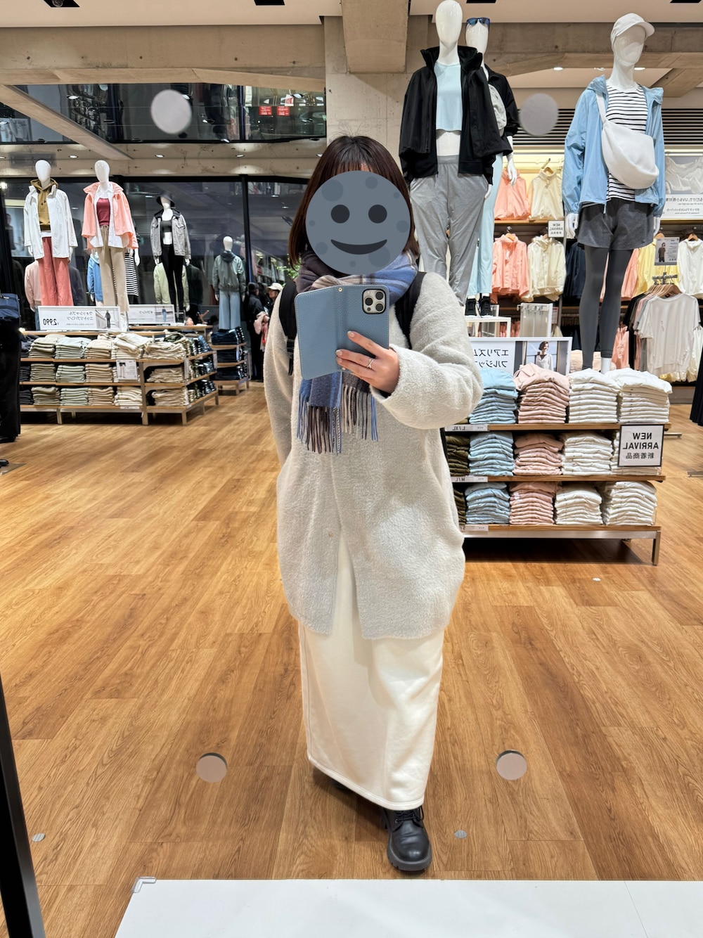 グレー系のジャケット/アウター、ブルー系のニット/セーター、ホワイト系のスカートを着用したレディースの冬コーディネートの1枚目の写真