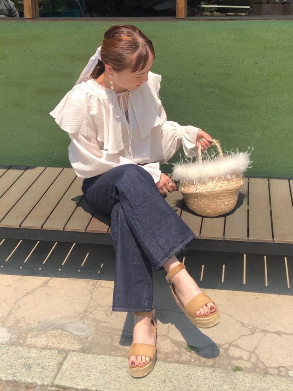 ブルー系のデニムパンツ、ベージュ系のサンダル、ホワイト系のシャツ/ブラウスを着用したレディースの春コーディネートの1枚目の写真