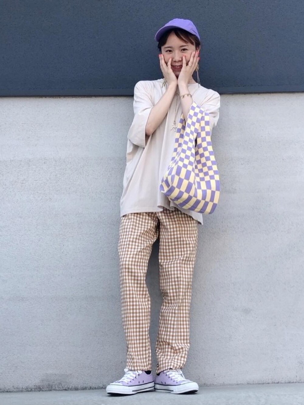 オレンジ系のパンツ、ベージュ系のTシャツ/カットソー、イエロー系のトートバッグを着用したレディースの春コーディネートの1枚目の写真