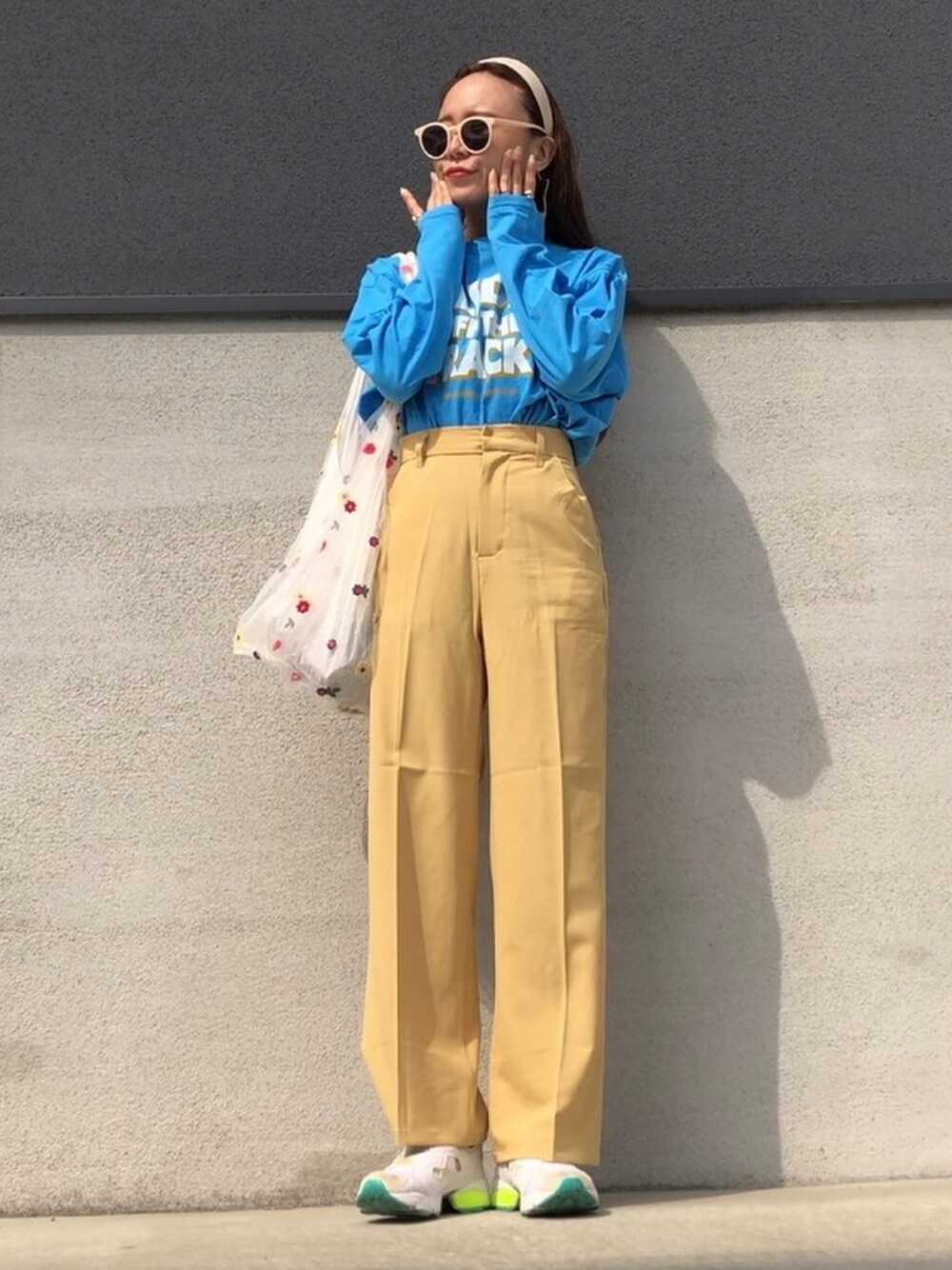 イエロー系のその他パンツ、ブルー系のTシャツ/カットソー、ホワイト系のスニーカーを着用したレディースの春コーディネートの1枚目の写真