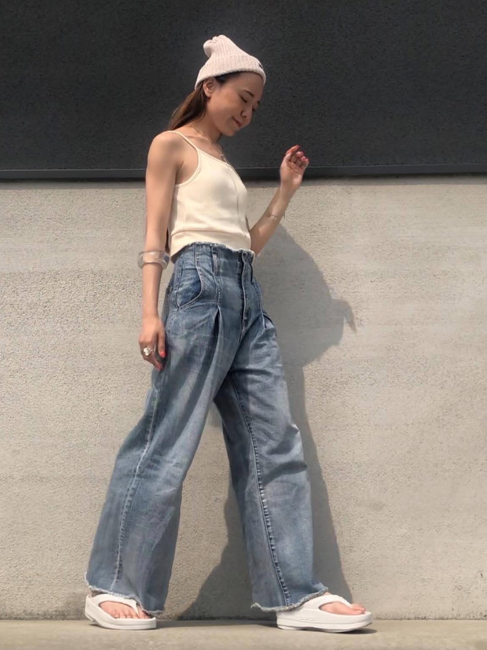 ブルー系のデニムパンツ、ホワイト系のキャミソール、ホワイト系のサンダルを着用したレディースの夏コーディネートの1枚目の写真