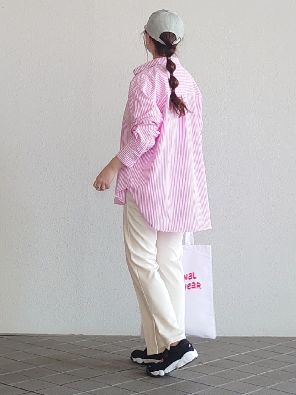 ピンク系のシャツ/ブラウス、ホワイト系のTシャツ/カットソー、ホワイト系のスラックスを着用したレディースの春コーディネートの2枚目の写真