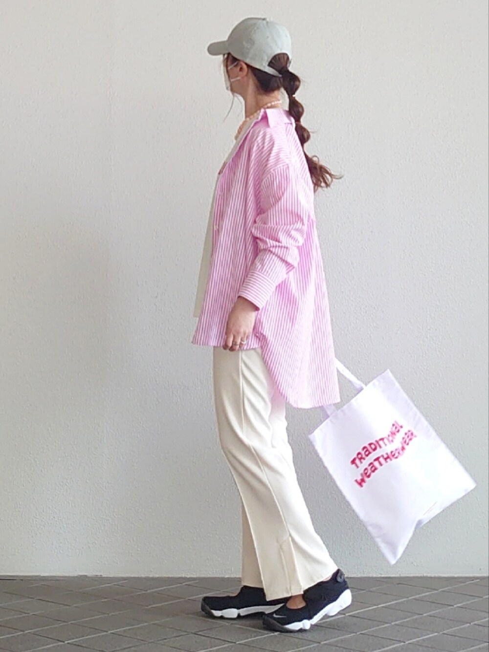 ピンク系のシャツ/ブラウス、ホワイト系のTシャツ/カットソー、ホワイト系のスラックスを着用したレディースの春コーディネートの4枚目の写真