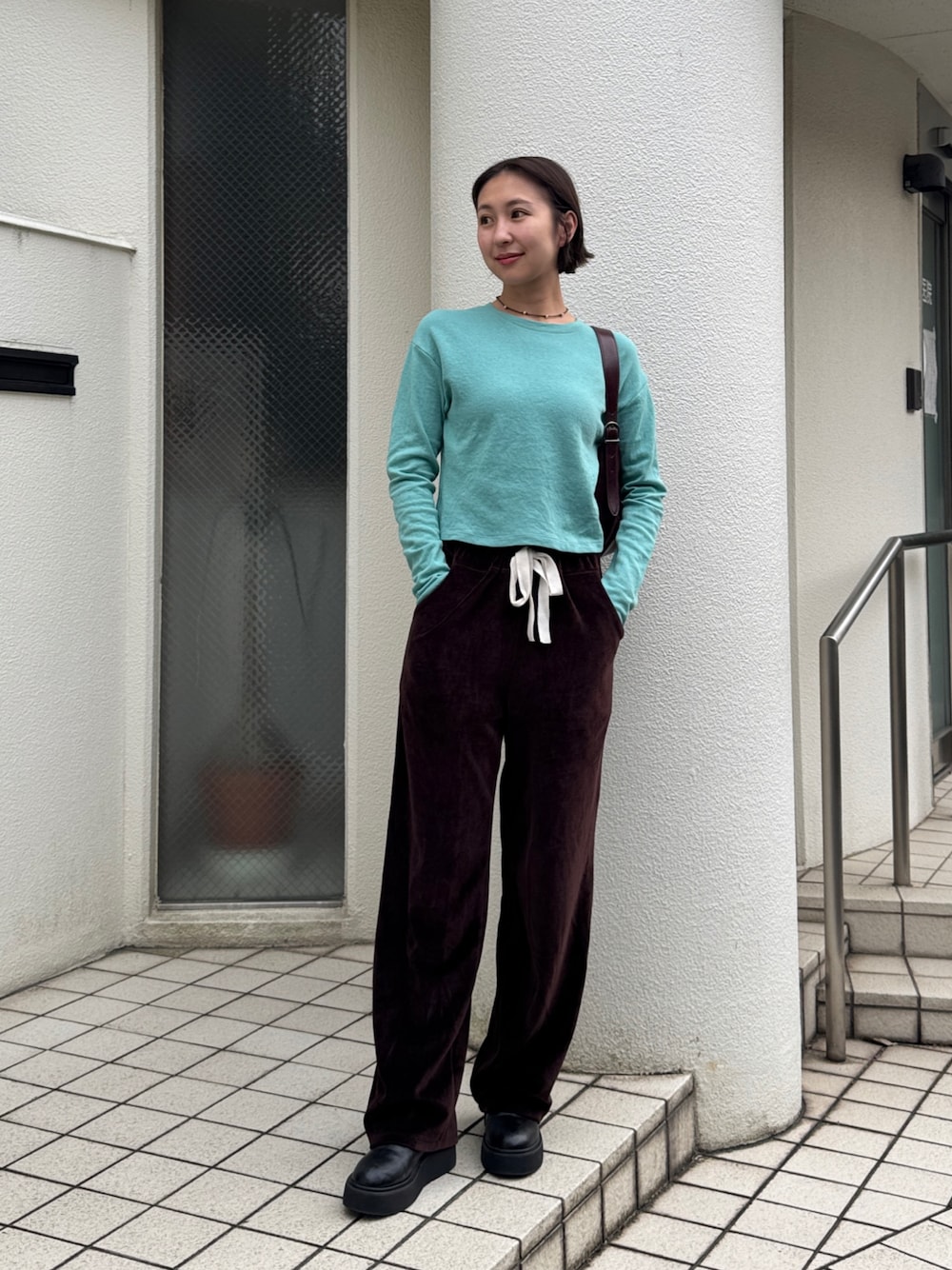 グリーン系のTシャツ/カットソー、ブラウン系のスウェットパンツ、ブラック系のブーツを着用したレディースの秋コーディネートの1枚目の写真