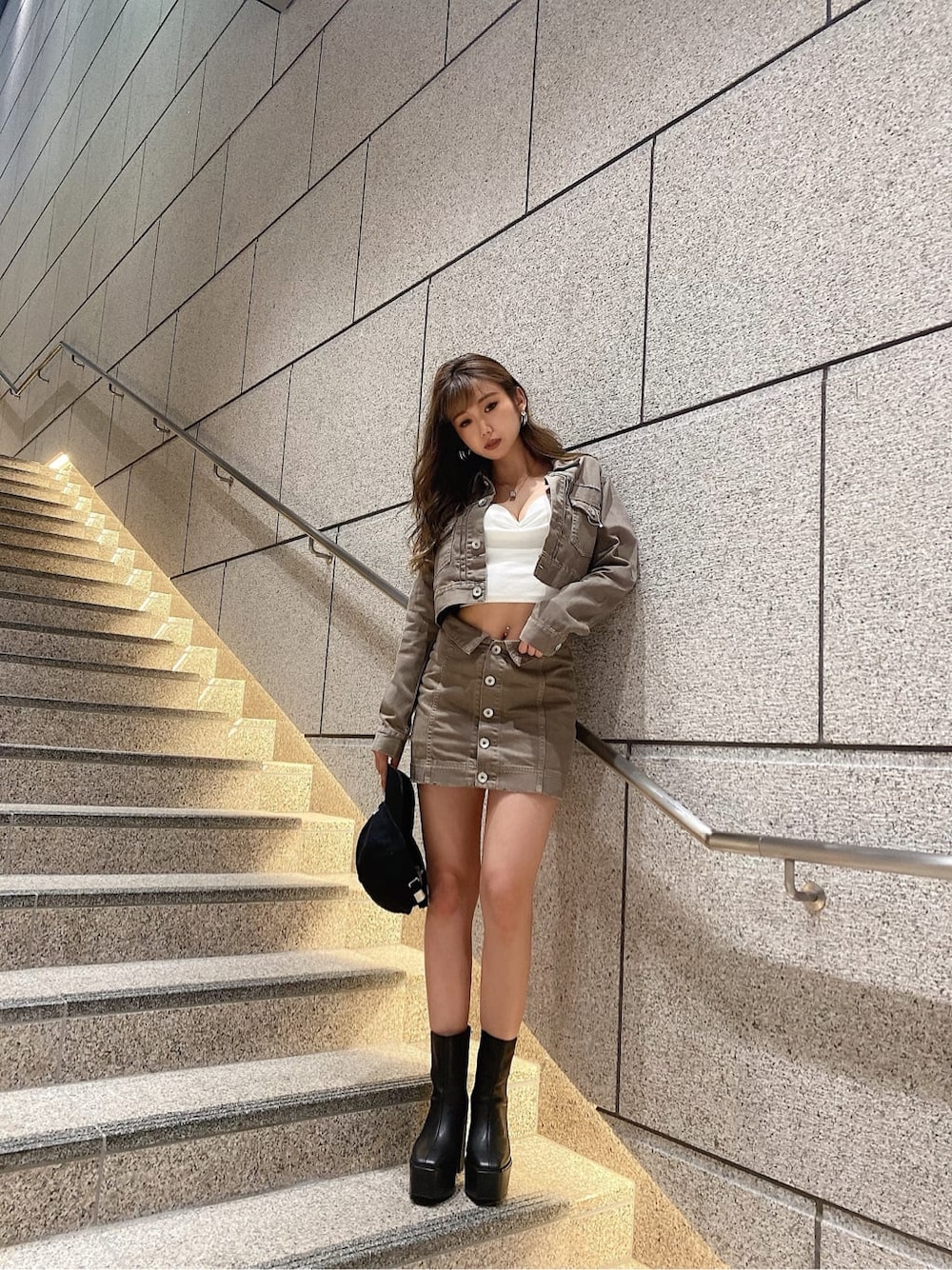 ベージュ系のデニムスカート、ブラック系のブーツ、ベージュ系のデニムジャケットを着用したレディースの夏コーディネートの1枚目の写真