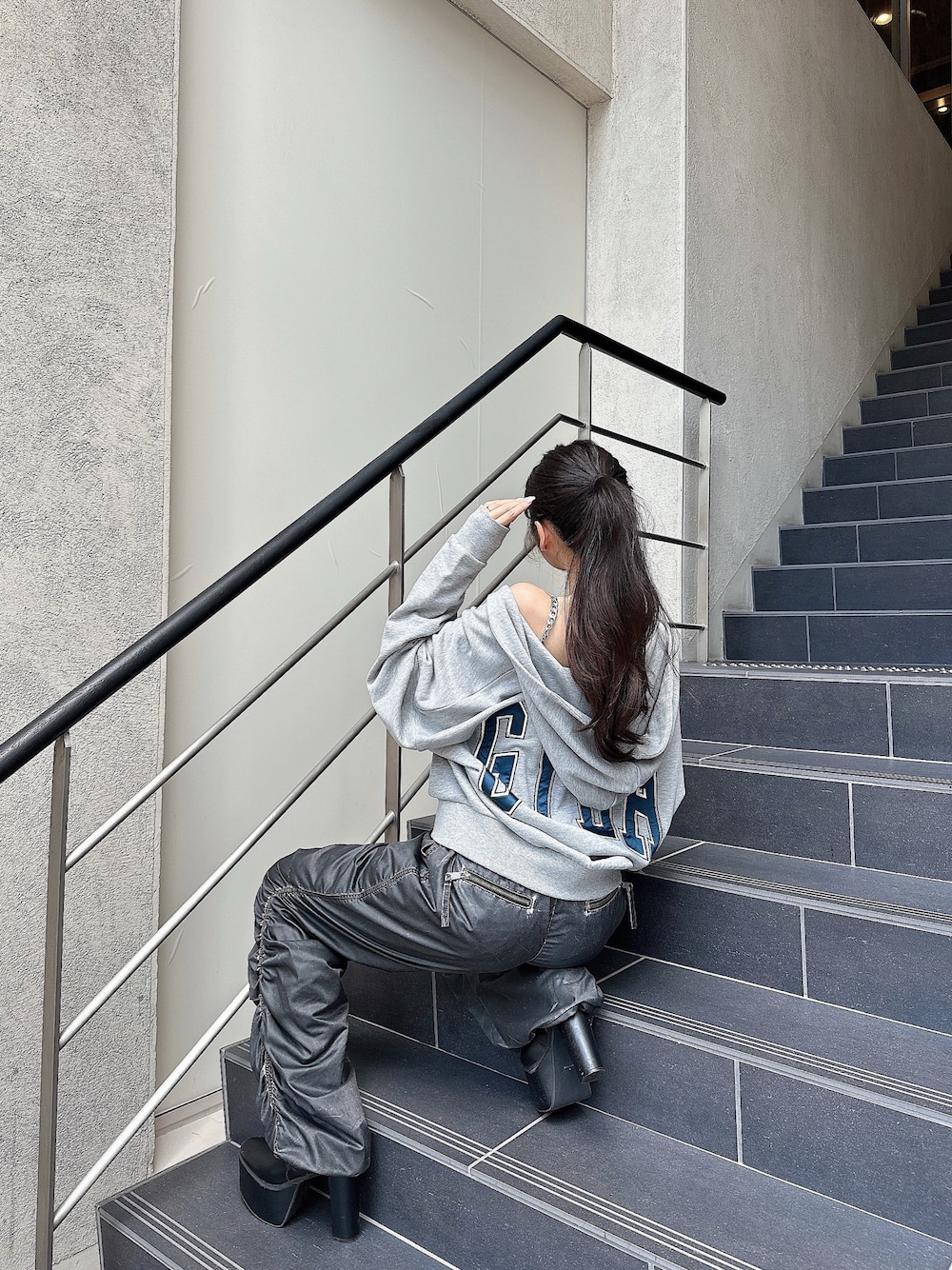 グレー系のパーカー、グレー系のその他パンツ、ブラック系のブーツを着用したレディースの秋コーディネートの1枚目の写真